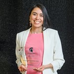 MSU Academic Advisor Erika Espinoza poses for a photograph holding the Chávez-Huerta Humanitarian Award, Staff of the Year, at the César E. Chávez and Dolores Huerta Community Leadership Awards in March 2023.
